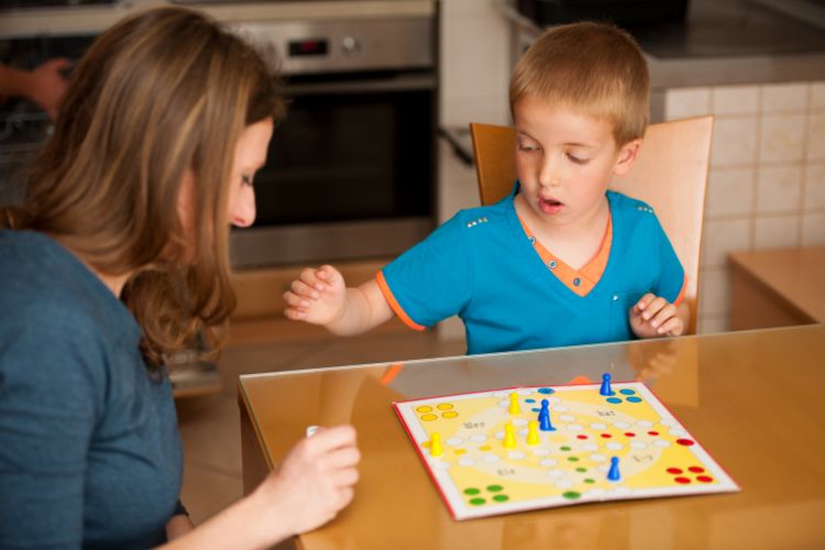 Parent and child playing a board game.