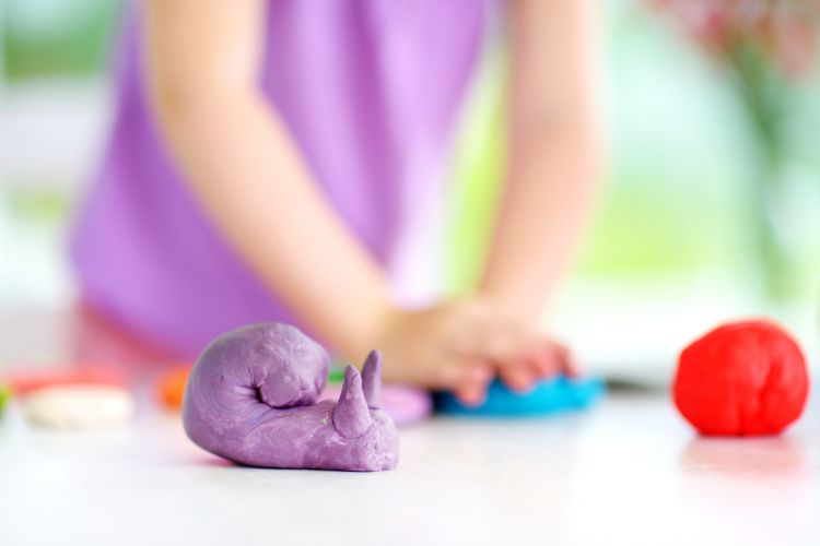 Child using playdough to learn through tactile experience
