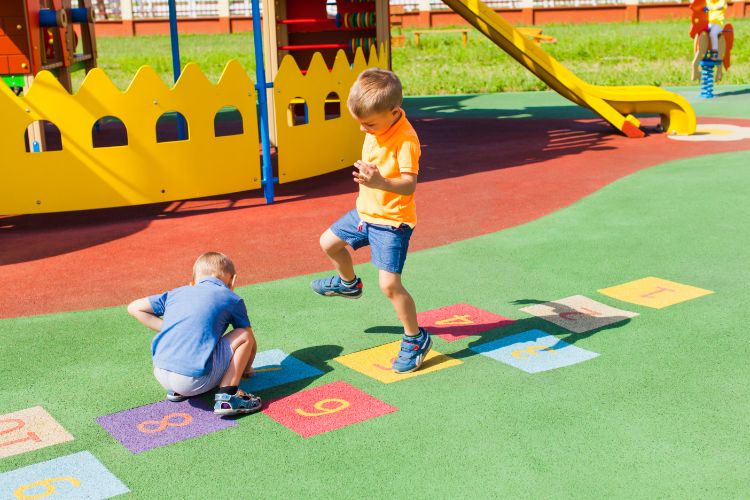 Children playing hopscotch, combining movement with learning