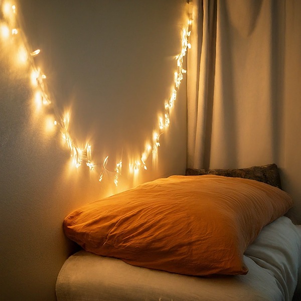 Fairy lights strung around headboard in dorm room