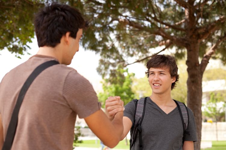Two college roommates shaking hands - Simple Habits for Great College Roommate Relationships