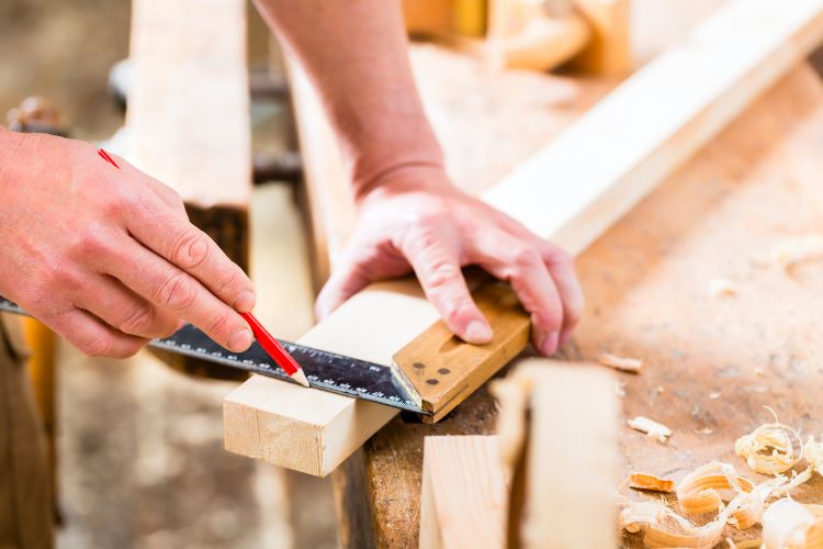 Hands using carpentry tools to craft a wooden object