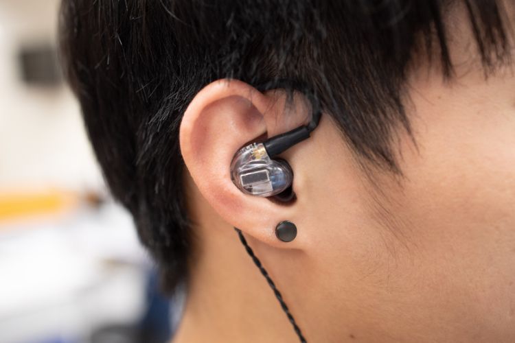 Ear with earbud highlighting the importance of listening for auditory learners